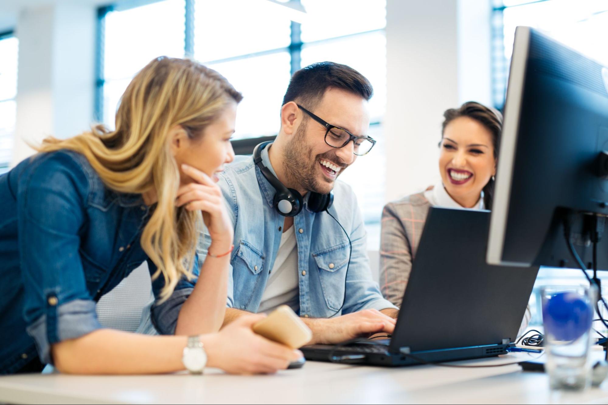 Stock photo of three co-workers working together at a computer