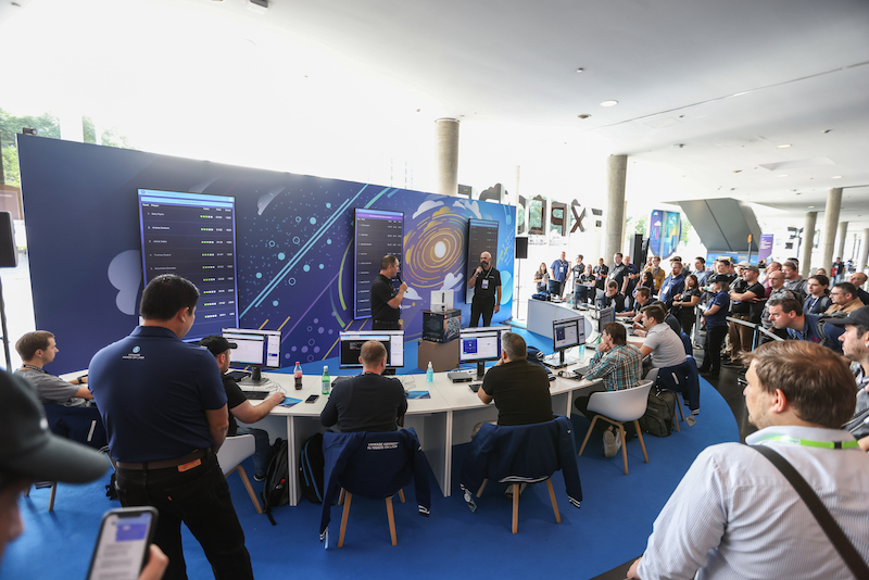 Finalists participate in a Hands-on Labs competition at VMware Explore Europe 2022, while a crowd looks on