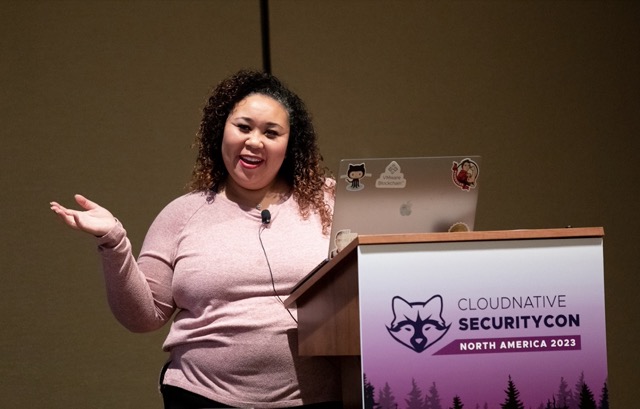 Natalie Fisher behind a podium for a talk at CloudNativeSecurityCon 2023