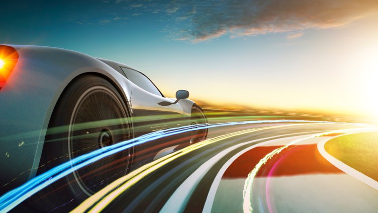 3D rendering of a brand-less grey sport car with light effect and motion blur . Race track background . Sunset scene .