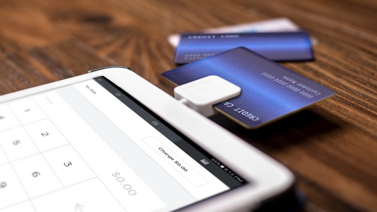 Credit card payment on a swipe or chip reader app on a tablet used by small or online businesses.  The electronic device is used as a modern cash register or for banking.