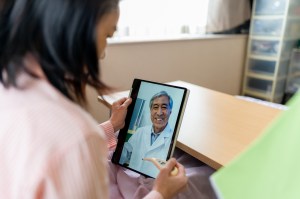 Telehealth - Woman video chatting with doctor on laptop at home
