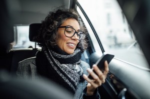 Businesswoman using mobile phone in taxi