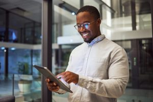 Employee smiling about results he's reading on his device.