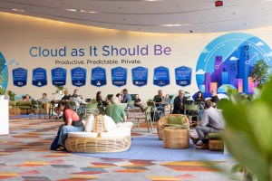 Attendees working in The Commons at VMware Explore 2025 in Las Vegas. The wall reads "Cloud as It Should Be".