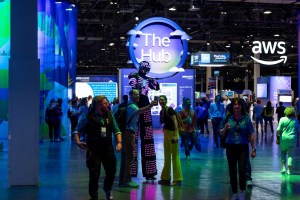 LED Stilt Walkers taking selfies with attendees in The Hub at VMware Explore 2025 in Las Vegas.