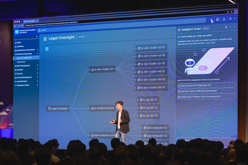 Speaker on stage at Explore on Tour in Tokyo with VCF content on display