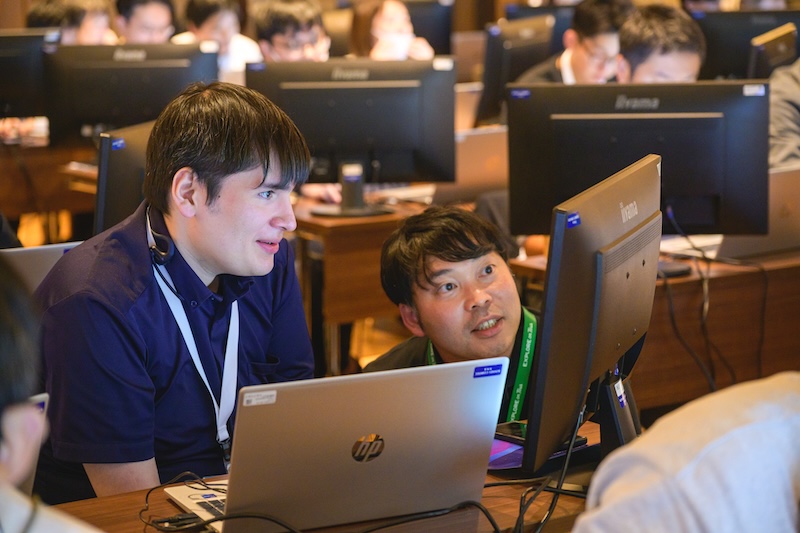 Attendees networking over computer screens at Explore on Tour in Tokyo