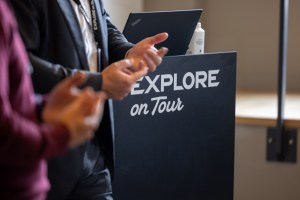 Explore on Tour branded podium with speaker hands