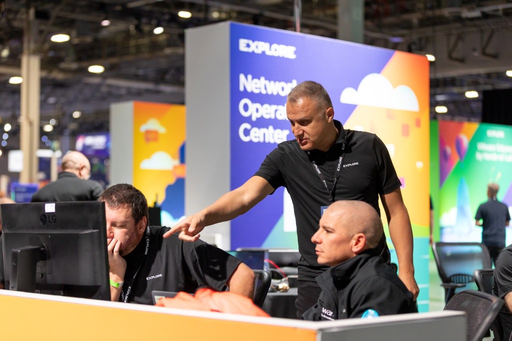 Attendees receiving 1‑1 expert training at computer monitor.