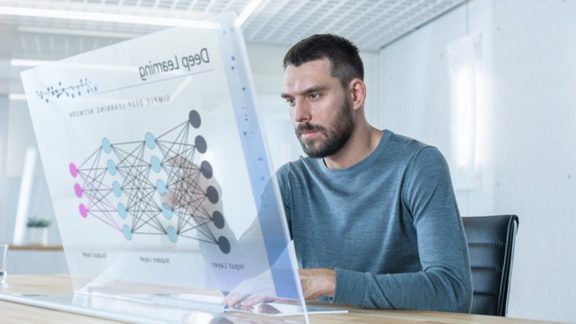 In the Futuristic Laboratory Creative Engineer Works on the Transparent Computer Display. Screen Shows Interactive User Interface with Deep Learning System, Artificial Intelligence Prototype.