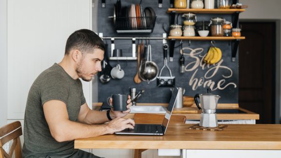 Handsome man uses a laptop to work from home, businessman or freelancer. Remote work.