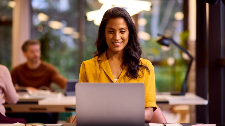 Mature Businesswoman Working On Laptop At Desk In Office