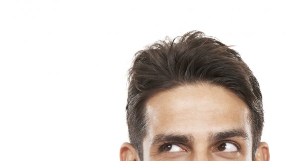 Cropped shot of a young man's face looking sideways towards copyspace