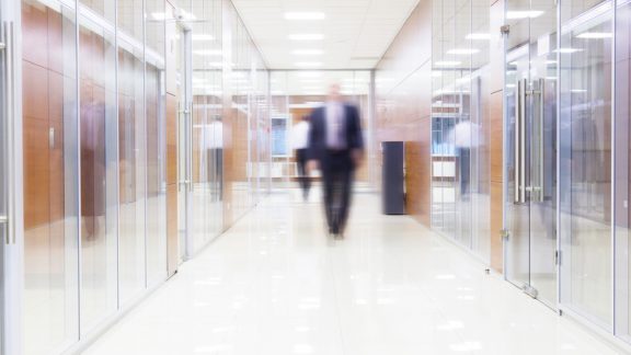 businessman goes along a corridor at modern office
