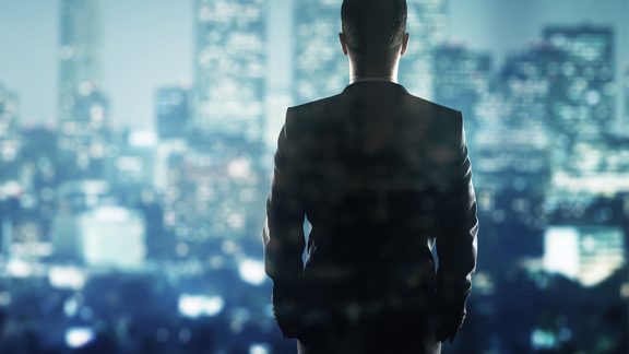 businessman in suit looking to night city