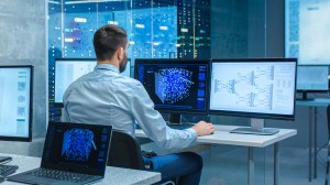 Man in front of computer screen in a futuristic office