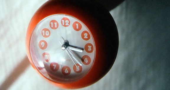 A sphere-shaped clock with its digits turned upside down. Indoors window light.NOTE: Film image, cannot be altered (much)