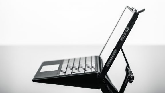 a modern, sleek and thin tablet with keyboard or laptop on a shiny surface