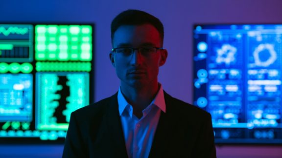 The man in glasses standing on screens background