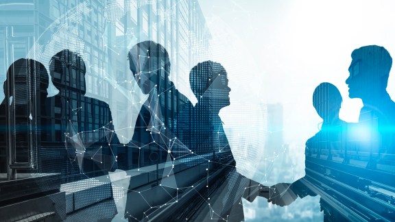 Silhouette view of business people team in group meeting on city office building background showing partnership success of business deal. Concept of teamwork, trust and agreement.