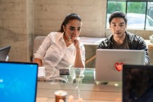 Young workers using PC and accomplishing tasks
