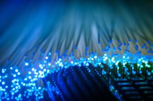 Microchip with blue glowing fiber optic wires in background