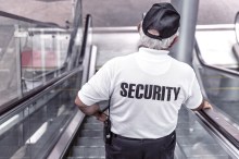Older security guard on escalator