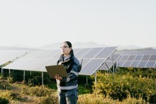 Woman with tablet near solar panels