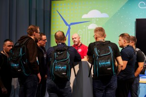 Group of attendees in a huddle wearing event backpacks and talking to an expert at VMware Explore in Las Vegas.