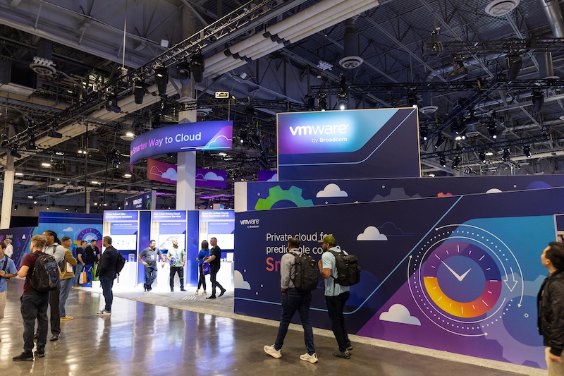 Attendees walking past the VMware by Broadcom booth in The Hub at VMware Explore 2025 in Las Vegas